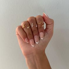 a woman's hand with three rings on her fingers and one ring in the middle