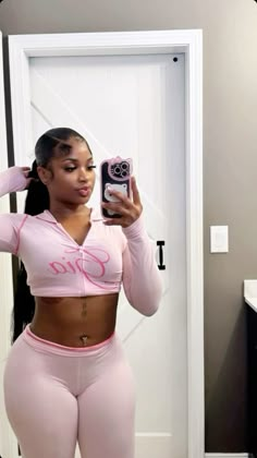 a woman taking a selfie in her pink sports bra top and matching leggings