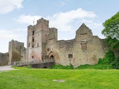 an old castle sitting on top of a lush green field