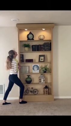 a woman standing in front of a book shelf