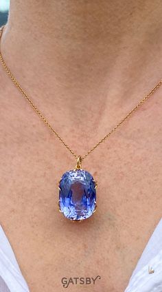 A gargantuan and gorgeous synthetic sapphire pendant. The impressive cushion cut stone – conservatively gauged at 50 carat – displays a glowing cornflower blue. The stone is mounted in a custom made yellow gold collet with and secured by eight split claws. Gemstone Necklaces