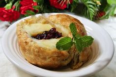 two pastries on a white plate with red flowers in the background and greenery