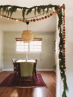 the dining room is decorated for christmas with garland and lights