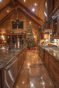 a christmas tree is in the middle of a kitchen with granite counter tops and stainless steel appliances