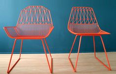 two orange chairs sitting on top of a wooden floor