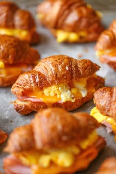 some croissants with eggs and cheese on them