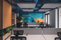 an office with blue and orange walls, chairs and desks in the foreground