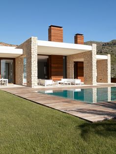 a house with a swimming pool in front of it and an outdoor lounge area next to it