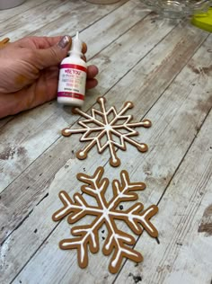 someone is making a snowflake out of gingerbread doughnuts and glue