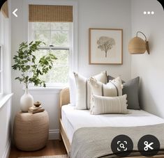 a bed room with a neatly made bed and a potted plant on the window sill