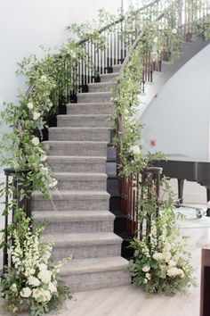 the stairs are decorated with flowers and greenery