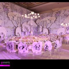 an elaborately decorated table and chairs with flowers on them in front of a backdrop