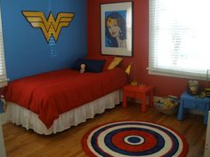 a bedroom decorated in red, white and blue with a wonder woman poster on the wall