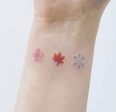 three small flowers on the wrist and one is red, white, and blue in color