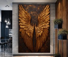 a large painting with gold wings on the wall next to a dining room table and chairs