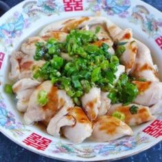 a white bowl filled with meat and green onions