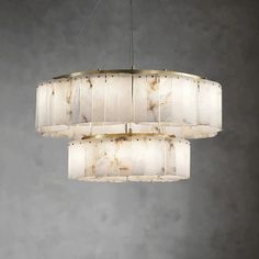 a large chandelier hanging from the ceiling in a room with concrete walls and flooring