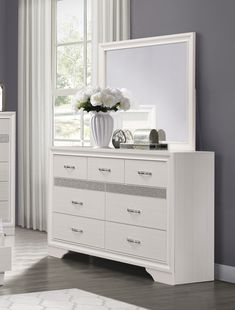 a white dresser and mirror in a room