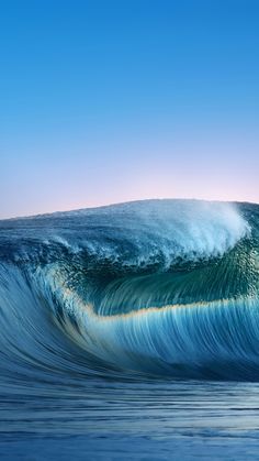 an ocean wave is breaking in to the blue sky and it looks like something out of water