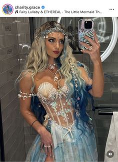 a woman in a blue and white costume taking a selfie