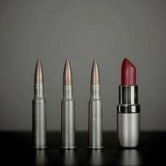 three lipsticks are lined up on a table with one red and the other silver