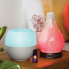 the aroma diffuser is next to an air purifying device on a table