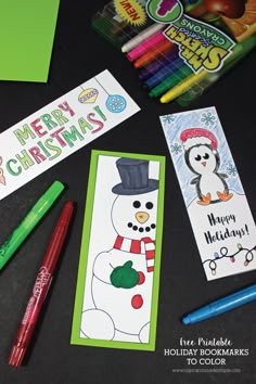 some christmas cards and markers are laying on a table with pencils, markers and pens