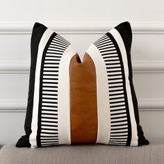 a black and white striped pillow sitting on top of a couch