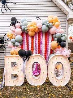 a large balloon sign that says boo with balloons around it