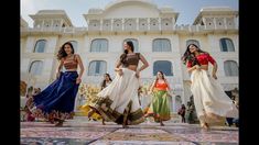 three women are dancing in front of a building