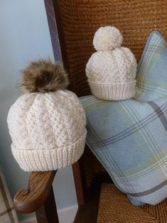 two hats sitting on top of a chair next to a pillow