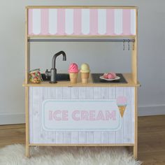 an ice cream stand with pink and white striped awnings on the top shelf