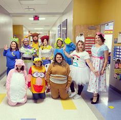 a group of people dressed up in costumes posing for a photo at the hospital hallway