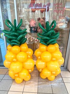 two large yellow balloons shaped like pineapples