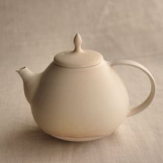 a white teapot sitting on top of a table