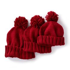 three red knitted hats with pom - poms