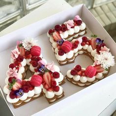 a box filled with cupcakes covered in frosting and topped with strawberries