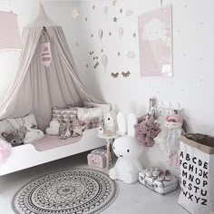 a bedroom with pink and white decor, including a teepee tent over the bed