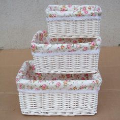 three white wicker baskets stacked on top of each other with floral fabric linings