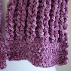 a purple crocheted scarf hanging from a hook