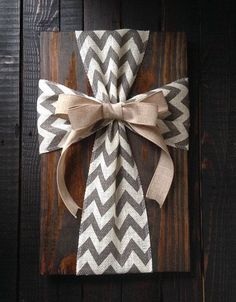 a gift wrapped in burlock and tied with a bow on top of a wooden board