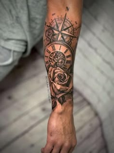 a man's arm with a rose and compass tattoo on it