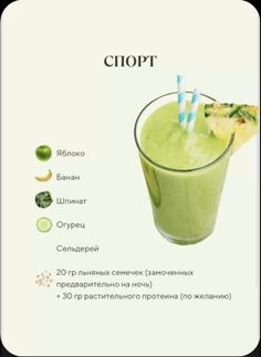 a green smoothie in a tall glass with two blue and white striped straws