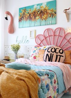 a bed with pink headboard and palm trees on the wall above it, in a bedroom