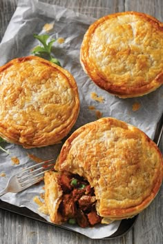 three meat pies on wax paper with a fork