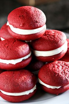 red velvet macaroons with white frosting stacked on top of eachother