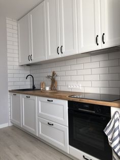 a kitchen with white cabinets and black appliances