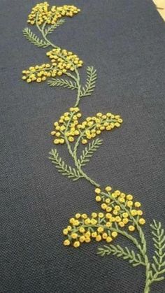 a close up of a piece of cloth with yellow flowers on it and green leaves