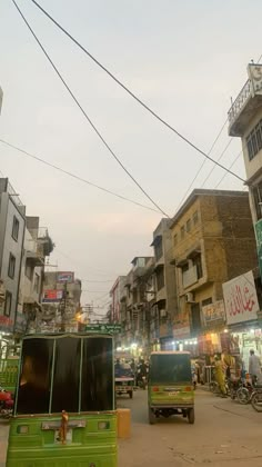 a busy street with cars, motorcycles and people