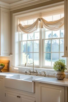 a kitchen window with white cabinets and curtains